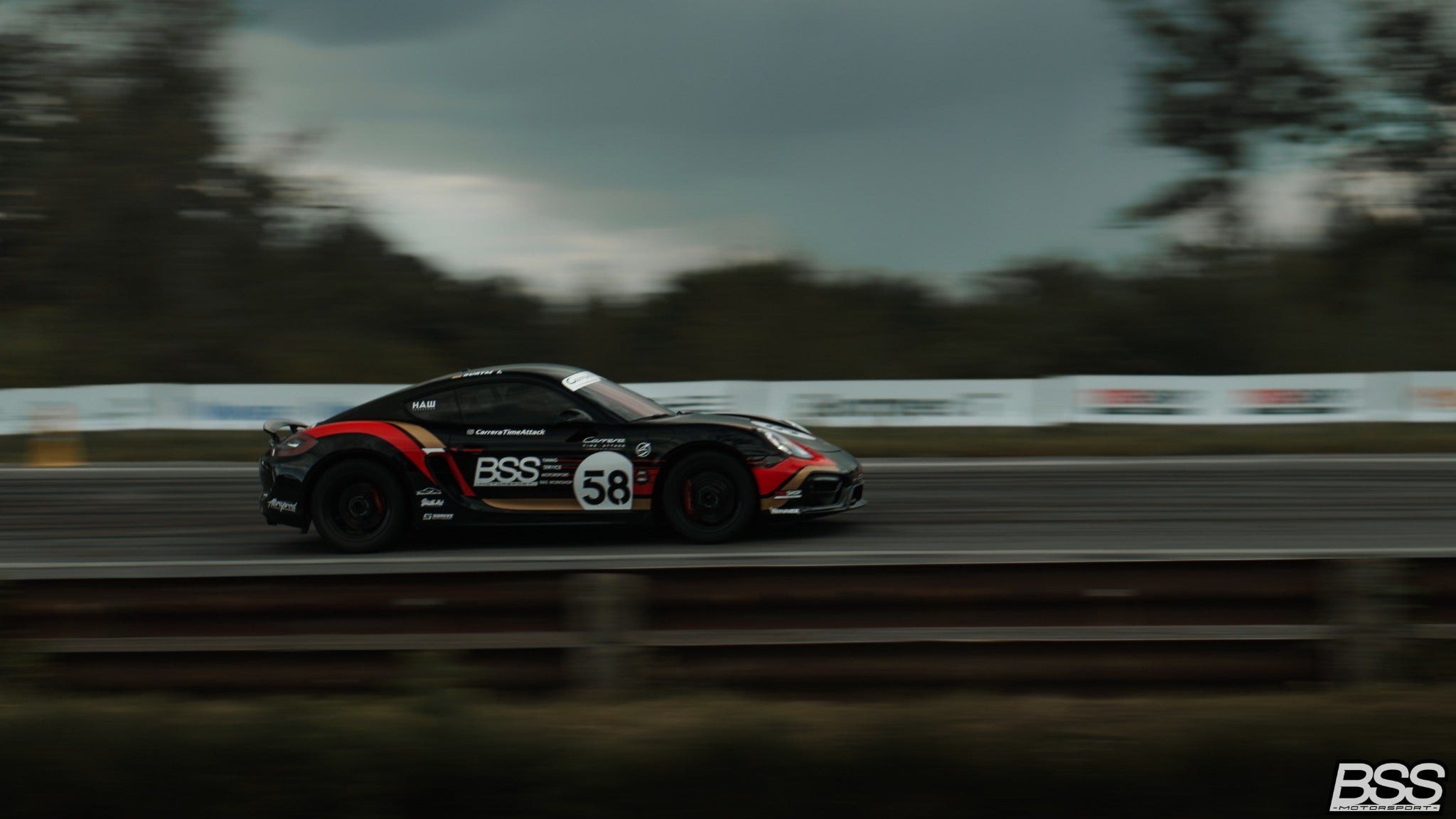 Black Porsche Cayman 58 side view on track